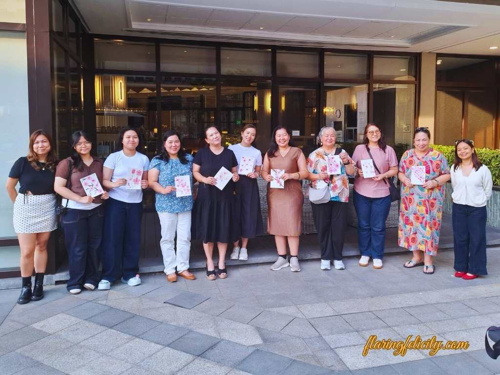 Watercolor workshop students holding completion certificates and finished paintings.